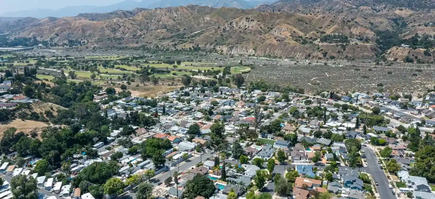 Aerial view of a Sunland neighborhood with the foothills rising behind it